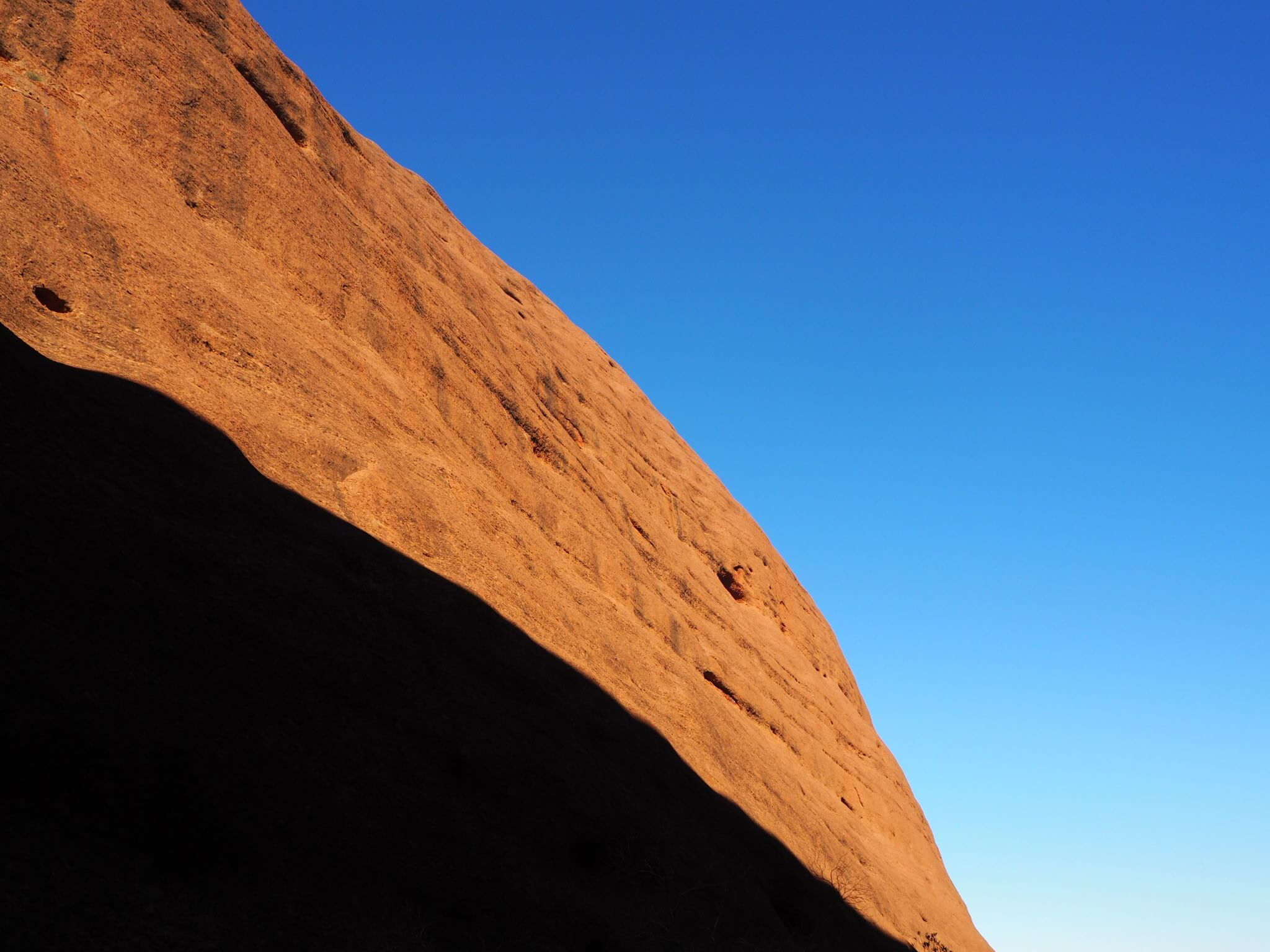 オーストラリアのウルル、カタジュタ国立公園の岩肌と青空